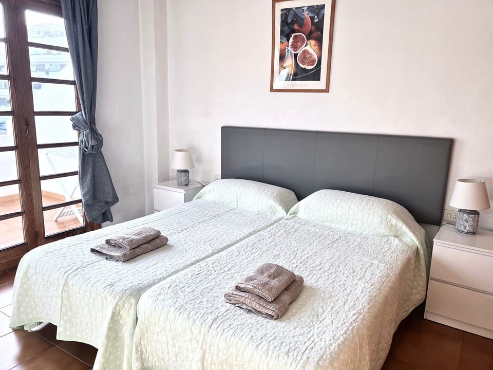 Large bedroom with twin beds and fitted wardrobe and direct access to the balcon