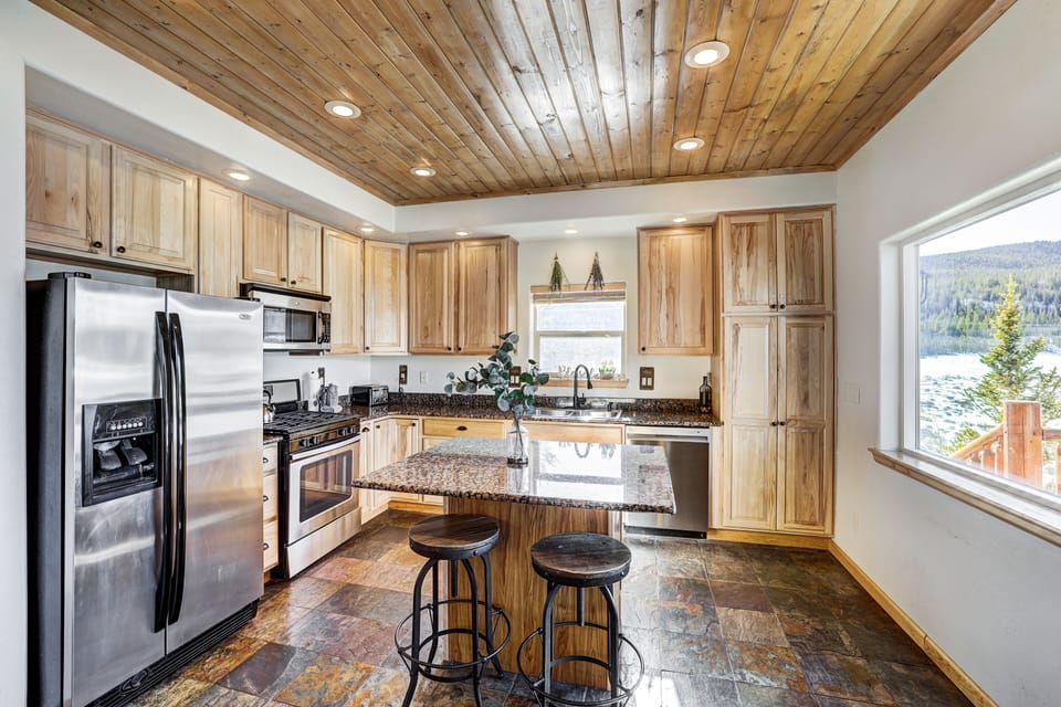 Modern kitchen with wood accents and breakfast bar seating.