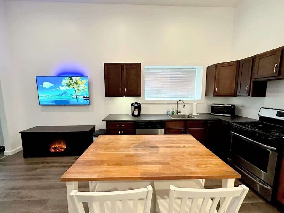 (KITCHEN) When entering the house, you'll find the kitchen equipped with stainless steel appliances, including a Keurig with K-cups, a dishwasher, microwave, and refrigerator.
