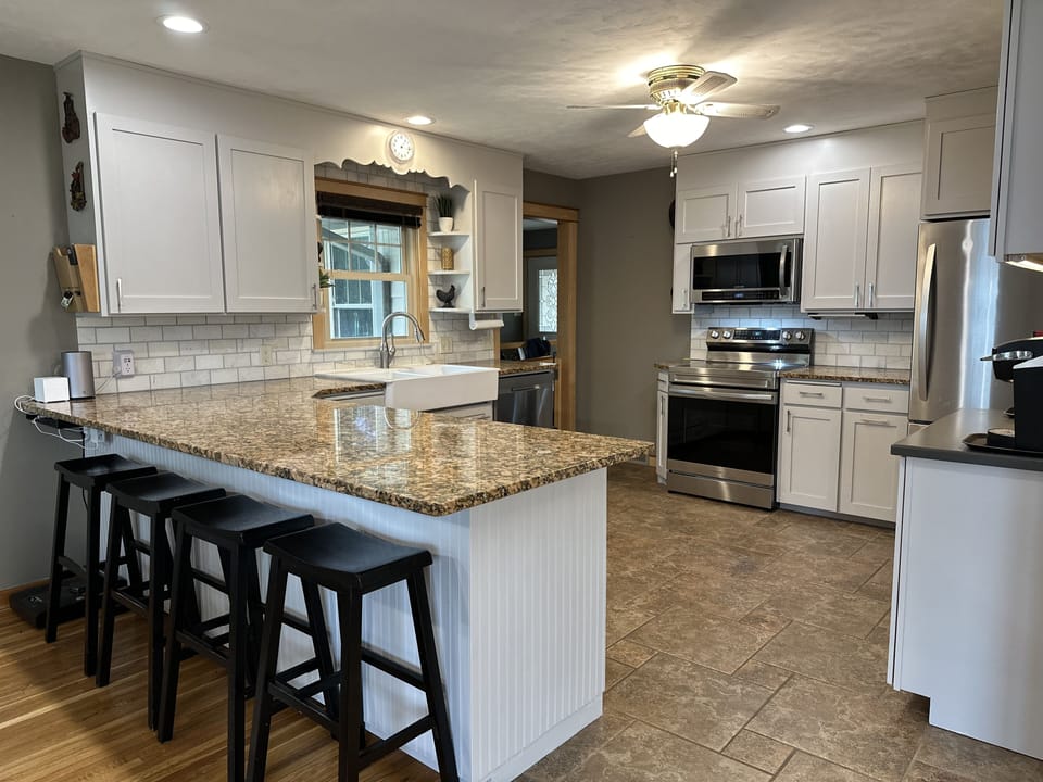 Kitchen with seating for 4 and a large workspace.