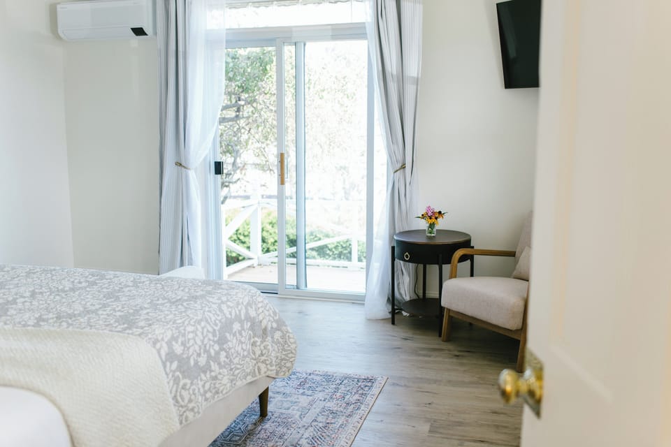 Step into comfort in this elegant king room featuring direct access to a private patio, cozy seating, flat-screen TV, and serene natural light. Perfect for relaxing after exploring Boothbay Harbor's scenic coast and charming downtown.