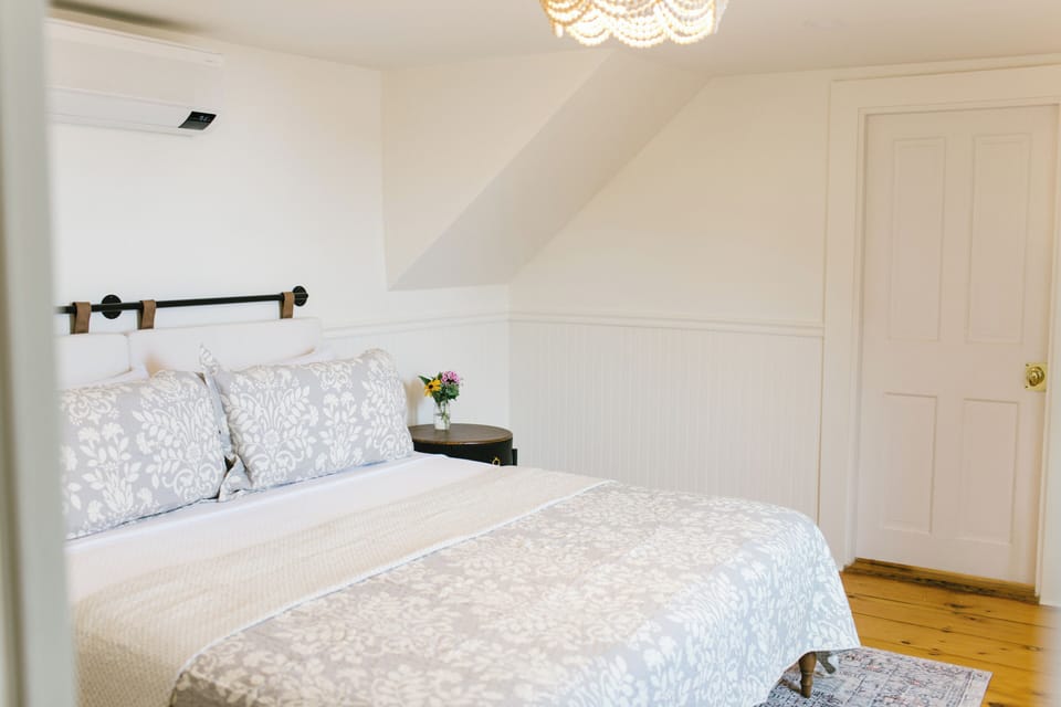 Relax in Room 5 at Greenleaf Inn, Boothbay Harbor. Features a plush queen bed, natural light, air conditioning, and vintage New England touches. Ideal for couples seeking peace and charm by the Maine coast.