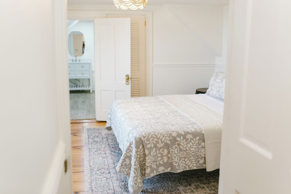 Room 5 at Greenleaf Inn features a queen bed, soft natural light, vintage charm, and a private ensuite bath—perfect for a relaxing Boothbay Harbor getaway in coastal Maine.