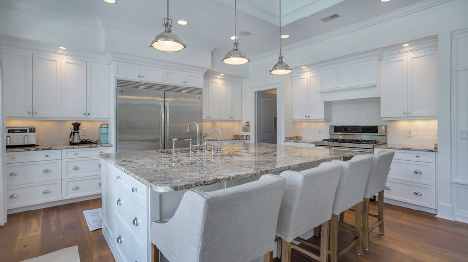 This stunning gourmet kitchen offers an impressive blend of luxury and function, showcasing an expansive granite island with seating for four