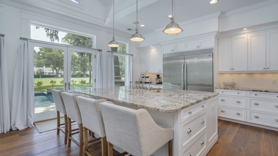 Pendant lighting brighten the space, while the wide layout and double-door refrigerator create an ideal environment for  gathering with ease.