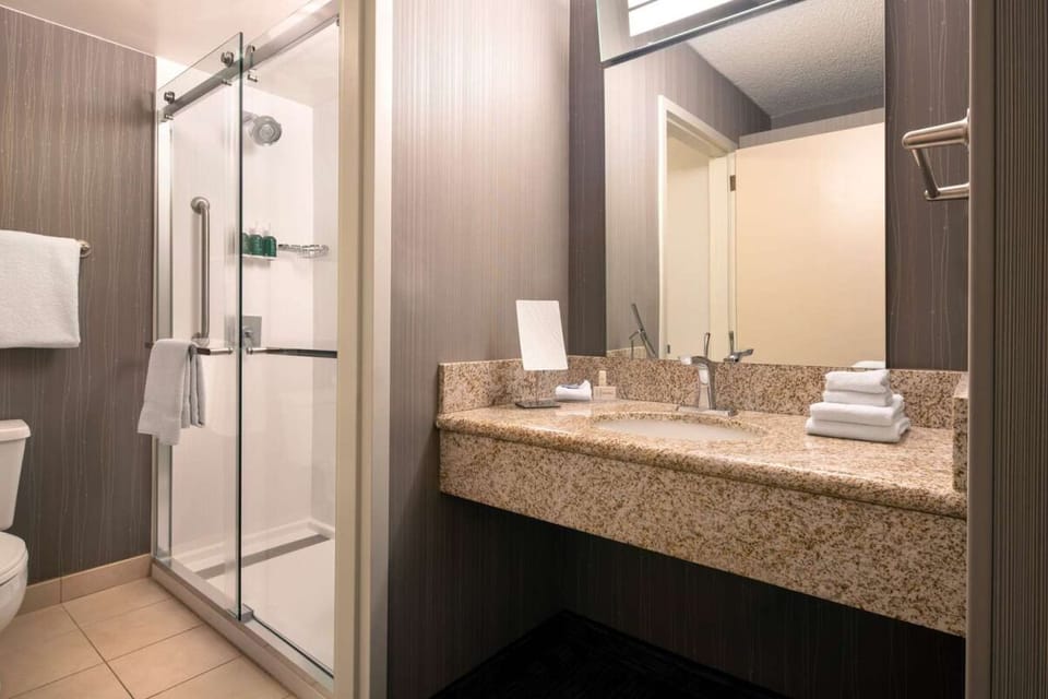 Refresh easily in a spotless bath with glass shower.