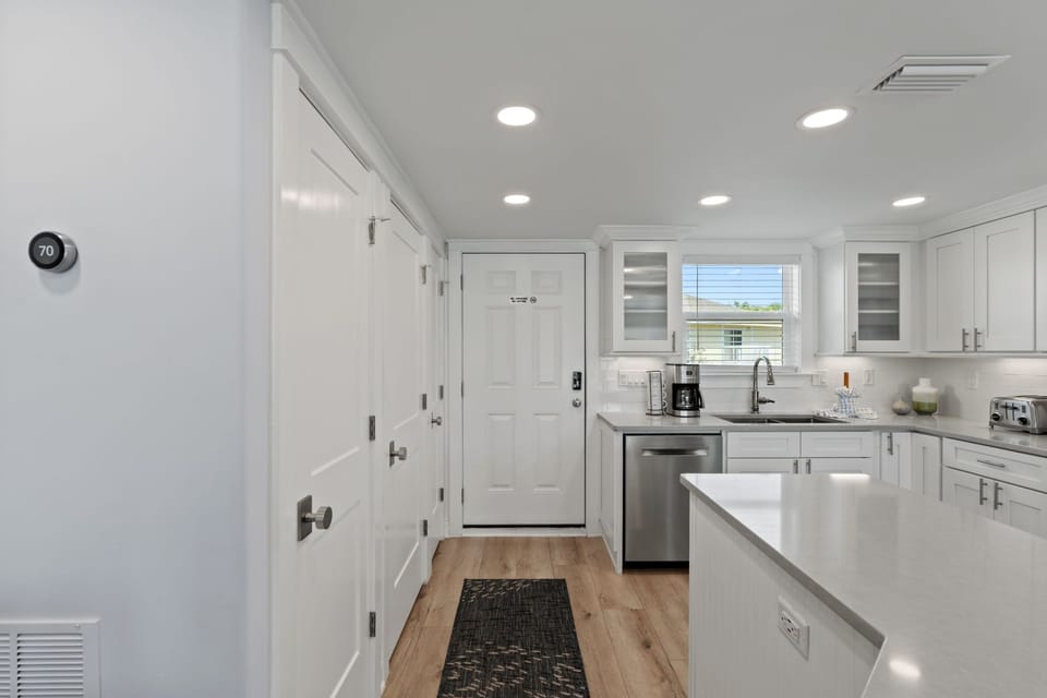 Your bright, modern kitchen is fully equipped with stainless steel appliances and sleek white countertops, perfect for preparing home-cooked meals during your stay.