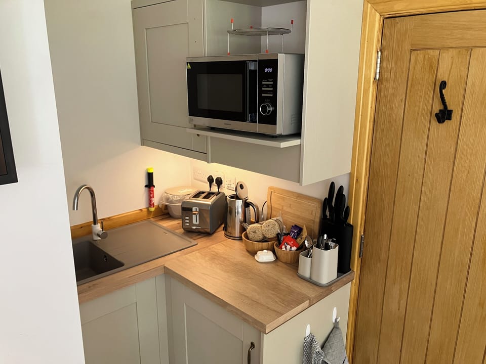 Kitchenette with combination microwave oven, kettle and toaster and cafetière. 