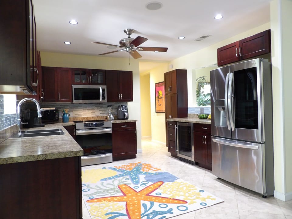 Stainless kitchen opens to dining area, induction stove, airfryer, 2 microwaves.