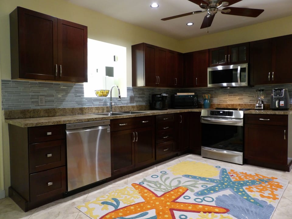 Kitchen w/ look thru to game rm, cleaning supplies, Keurig coffee pot & pod.