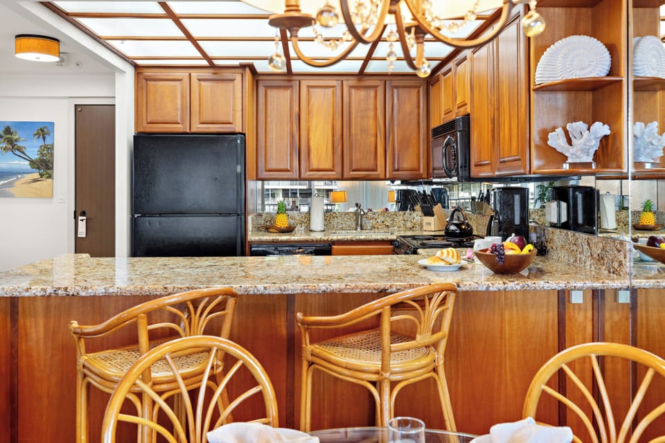 Bright and inviting open-concept kitchen featuring cabinetry, sleek countertops, and a spacious island that flows seamlessly into the living and dining areas. Perfect for entertaining or relaxing in comfort.