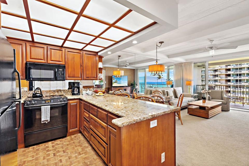 Bright and inviting open-concept kitchen featuring cabinetry, sleek countertops, and a spacious island that flows seamlessly into the living and dining areas. Perfect for entertaining or relaxing in comfort.