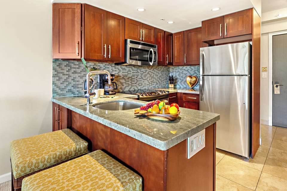 Prepare your favorite island-inspired meals in the beautifully updated kitchen featuring granite countertops, stainless steel appliances, and rich wood cabinetry.