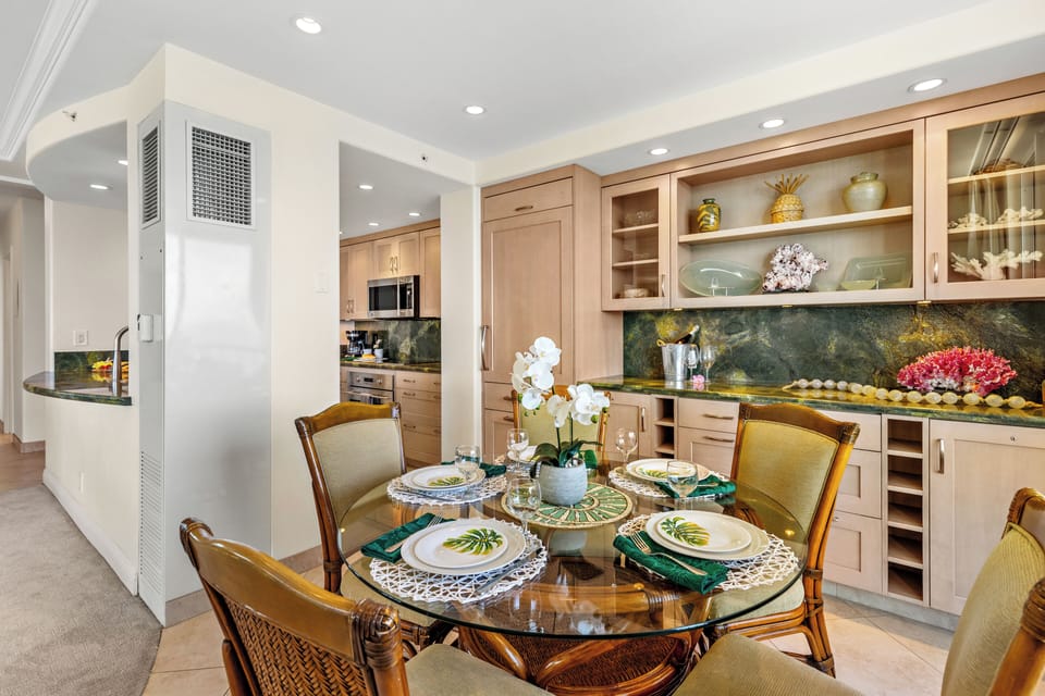 An inviting dining space where island elegance meets breathtaking ocean views. Gather around the beautifully set table, surrounded by warm textures, coastal-inspired décor, and soft ambient lighting.