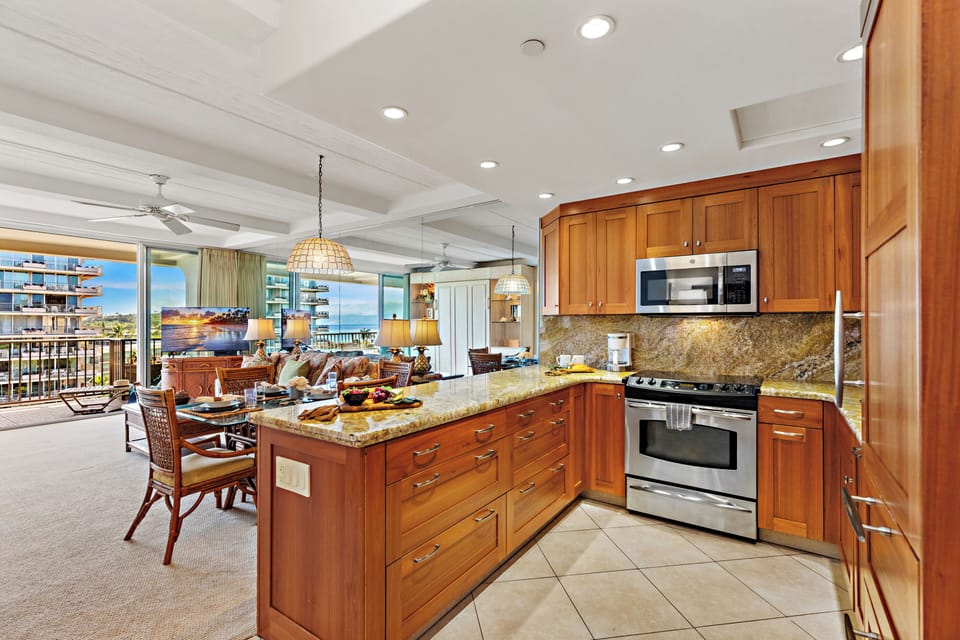 Bright and inviting open-concept kitchen featuring cabinetry, sleek countertops, and a spacious island that flows seamlessly into the living and dining areas. Perfect for entertaining or relaxing in comfort.