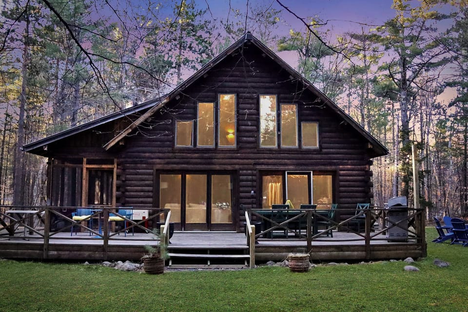 Surrounded by nature, the cabin’s backyard offers a private deck, dining area, and serene views through the windows.