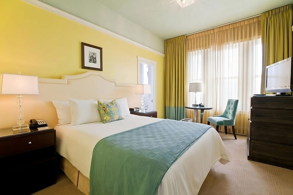 Unwind in a sunlit bedroom with crisp linens and calm.