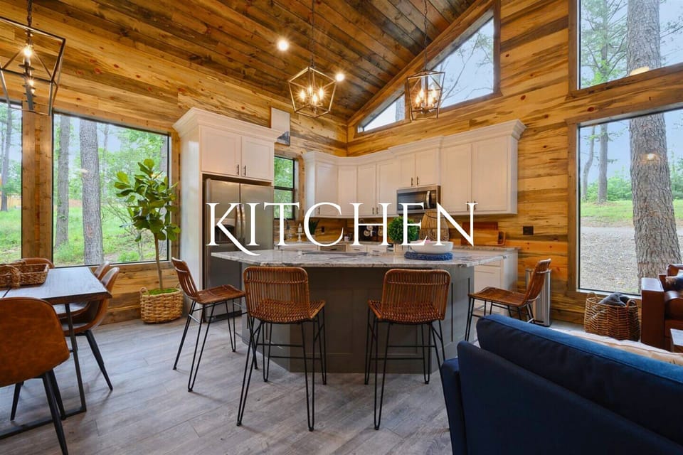 This well-equipped kitchen boasts white cabinetry, modern appliances, and a central island with wicker seating, perfect for socializing while preparing meals