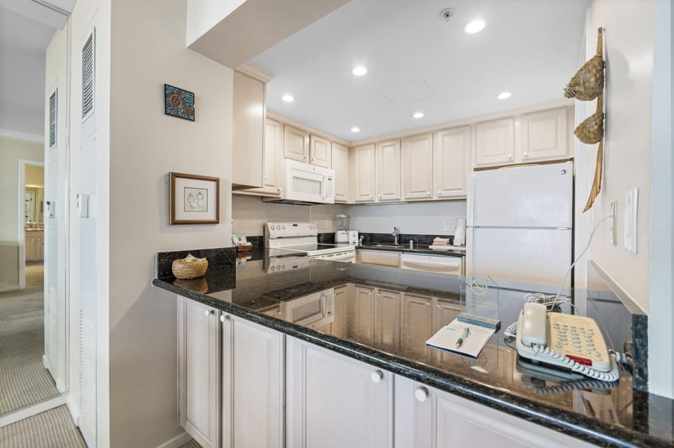 Your fully equipped kitchen features sleek granite countertops, modern white appliances, and ample cabinet space—perfect for preparing meals and enjoying a relaxed home-away-from-home experience.