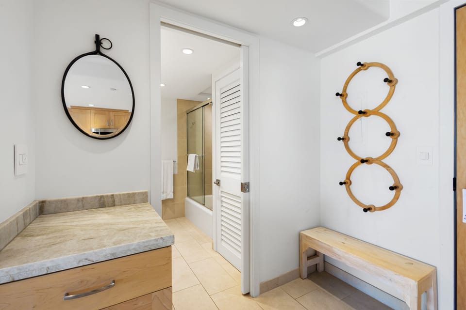 Freshen up in your bright, modern bathroom with natural wood details and a spacious walk-in shower—clean lines and coastal charm await.