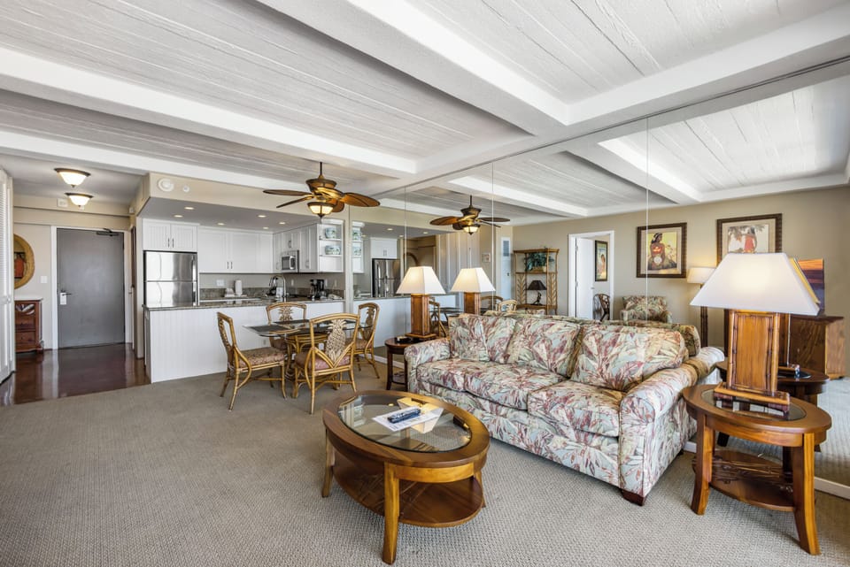 Step into your spacious island retreat, where ceiling fans stir tropical breezes above your open-concept living area. The fully equipped kitchen flows seamlessly into your dining and lounge spaces, all bathed in warm natural light.