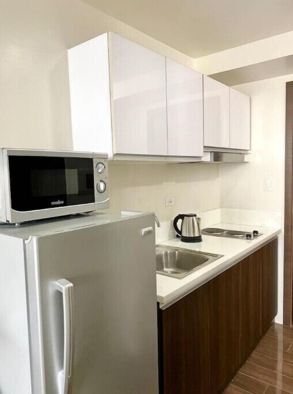 Kitchen is equipped with Refrigerator, Microwave, and 2 burner stove.
