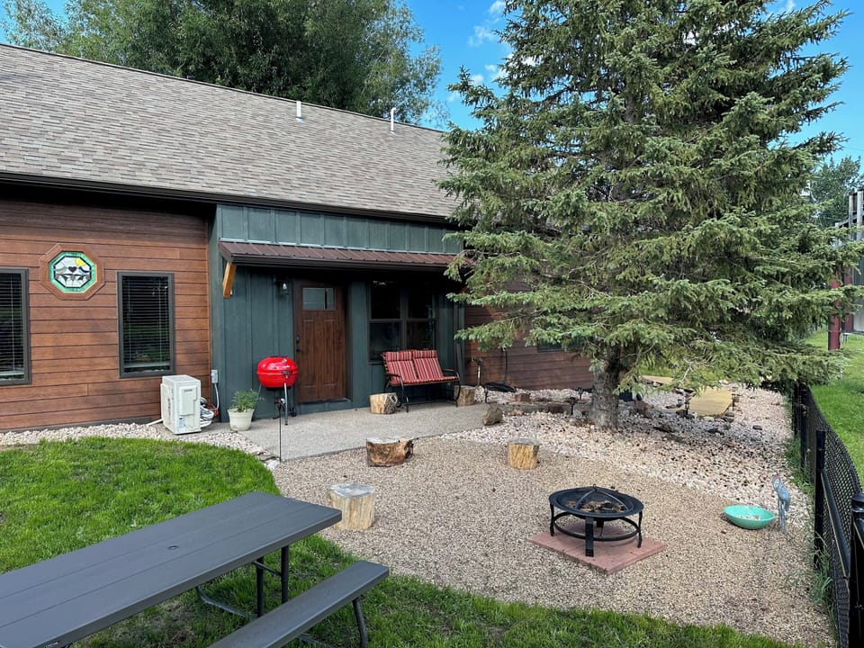 Back of our cabin, Chokecherry Hideout has grill, glider, firepit, table, view.