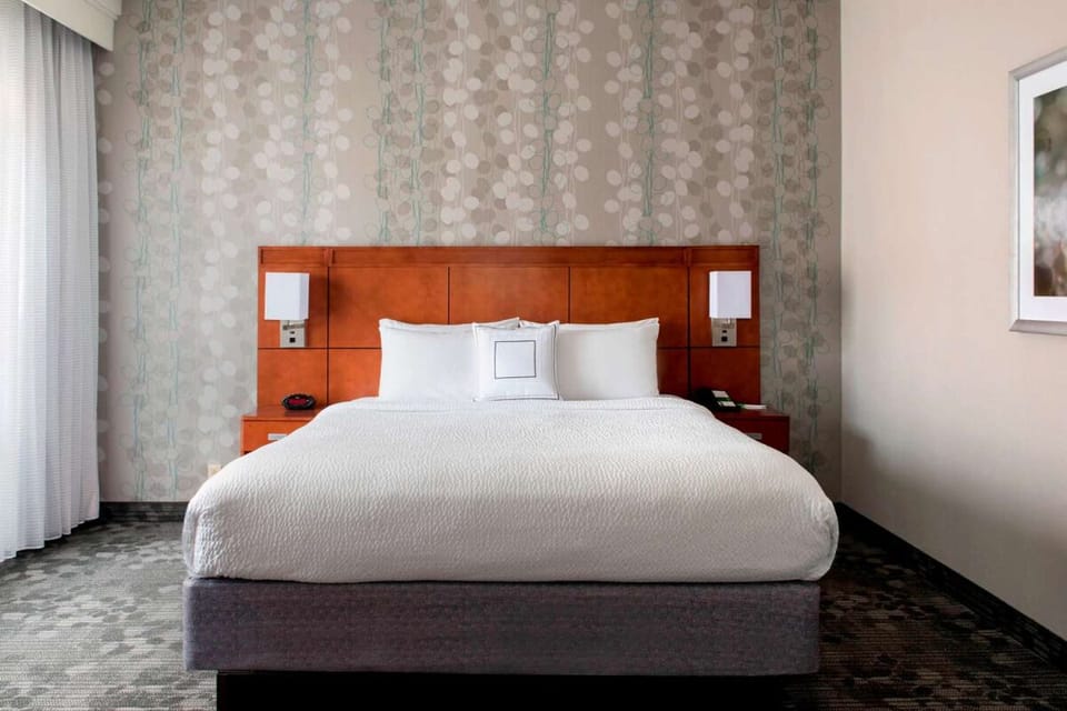 Unwind in a crisp king bed with soft, quiet comfort.