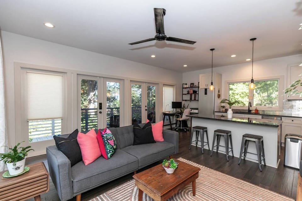 Enjoy natural light in the living room with glass doors leading to the private back deck, enhanced with window film for extra privacy.