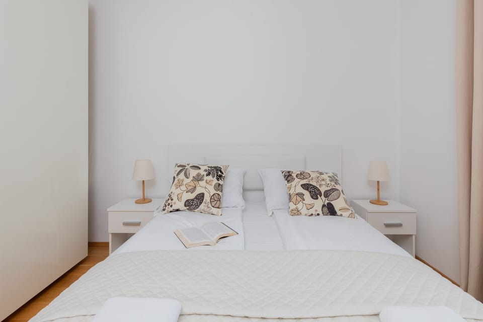 A cozy bedroom featuring a comfortable double bed, elegant bedding, and bedside lamps for a relaxing atmosphere.