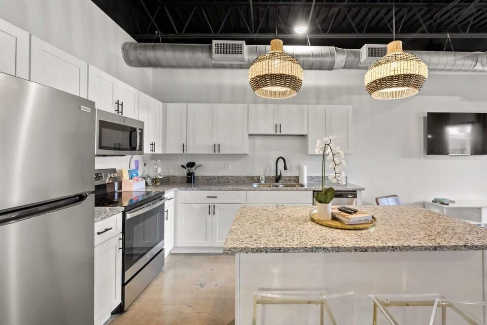 Experience the epitome of elegance in your own home with this pristine kitchen adorned with pristine white cabinetry and premium stainless steel appliances.