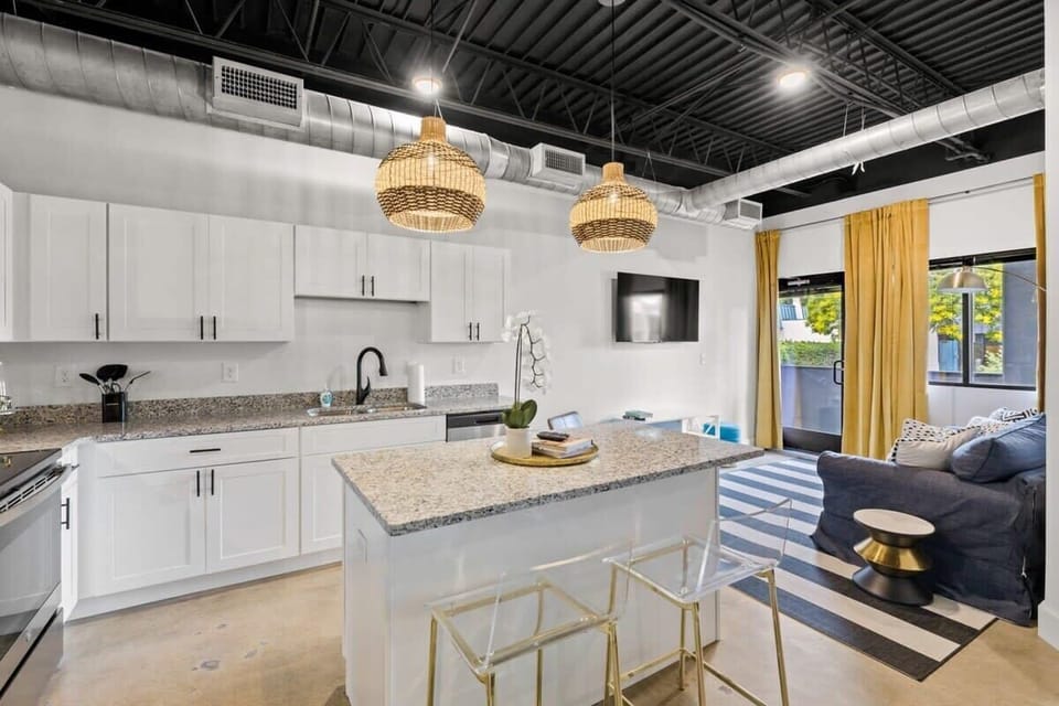 Step inside this chic urban oasis where the kitchen and living room meet in perfect harmony, creating a stylish and inviting space for both cooking and lounging.