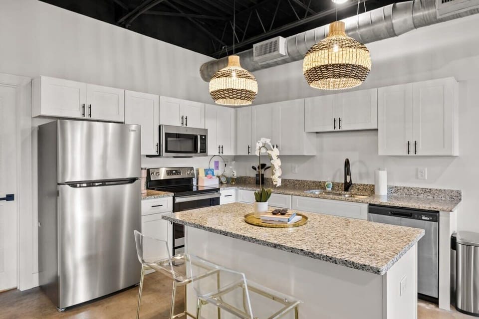 Experience the epitome of elegance in your own home with this pristine kitchen adorned with pristine white cabinetry and premium stainless steel appliances.