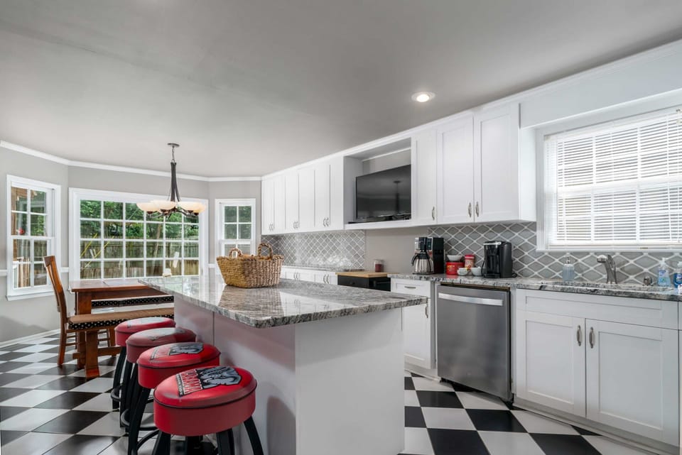 In this spacious kitchen, a granite top island bar doubles as an entertainment hub with an HDTV, while a complete set of cooking tools make meal preparation a breeze.