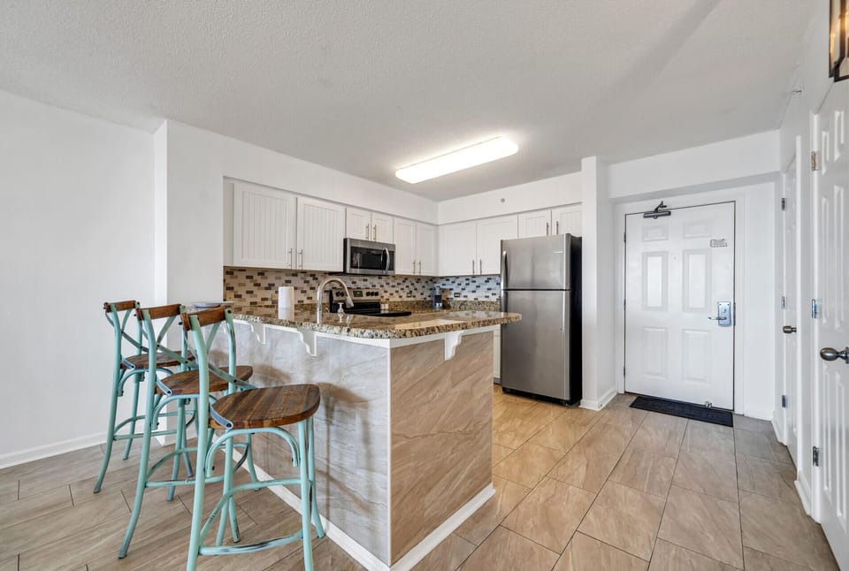 Your fully equipped kitchen awaits with granite countertops, stainless steel appliances, and a breakfast bar perfect for morning coffee.