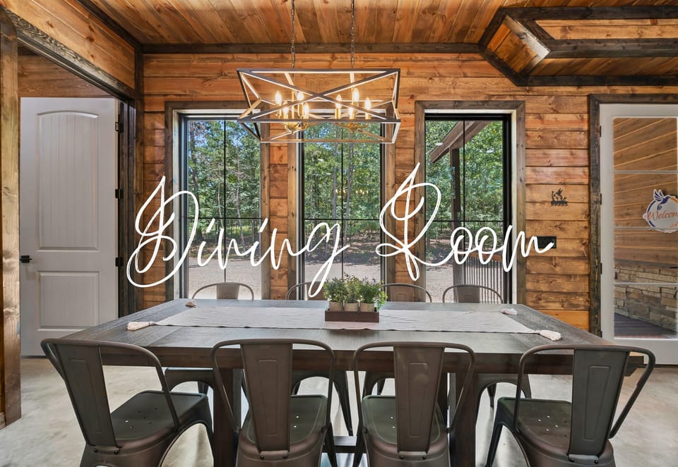 The dining room features a large wooden table with metal chairs, an artistic light fixture above, and a door leading outside