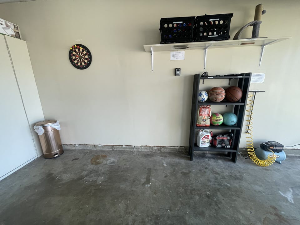 Magnetic dart board, basket ball, BBQ grill supplies and small air compressor.