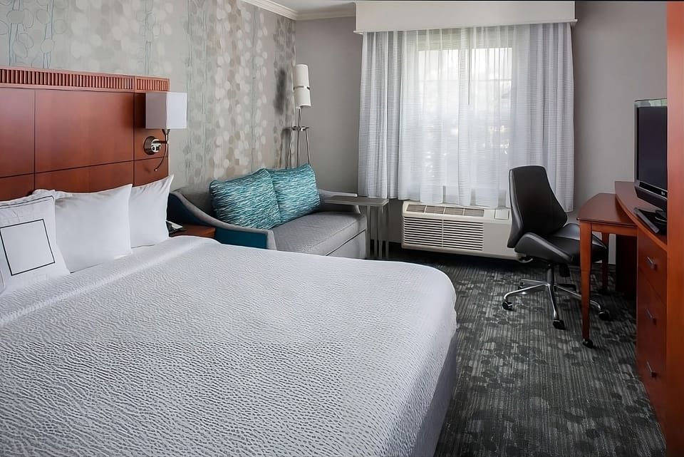 Relax in a bright room with bed and cozy sofa.