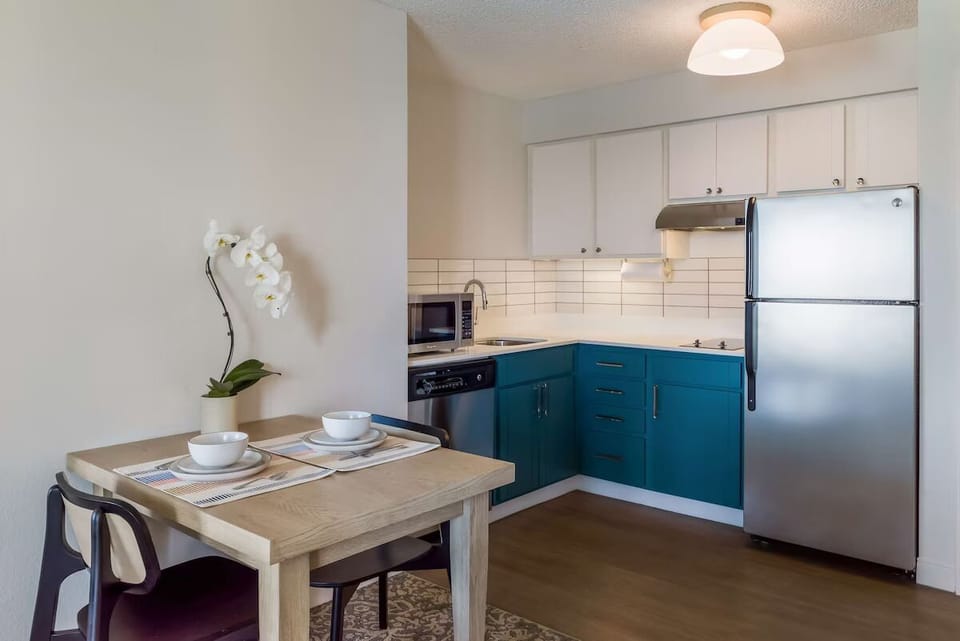 Sip coffee at the table beside a tidy, modern kitchenette