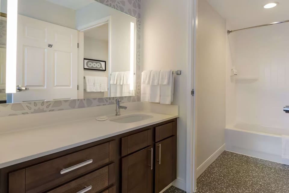 Refresh under a bright vanity mirror and clean, roomy shower
