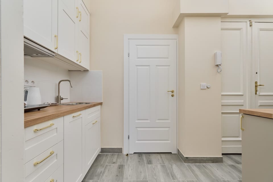 A minimalist white kitchen equipped with essential appliances, blending functionality with a polished design.