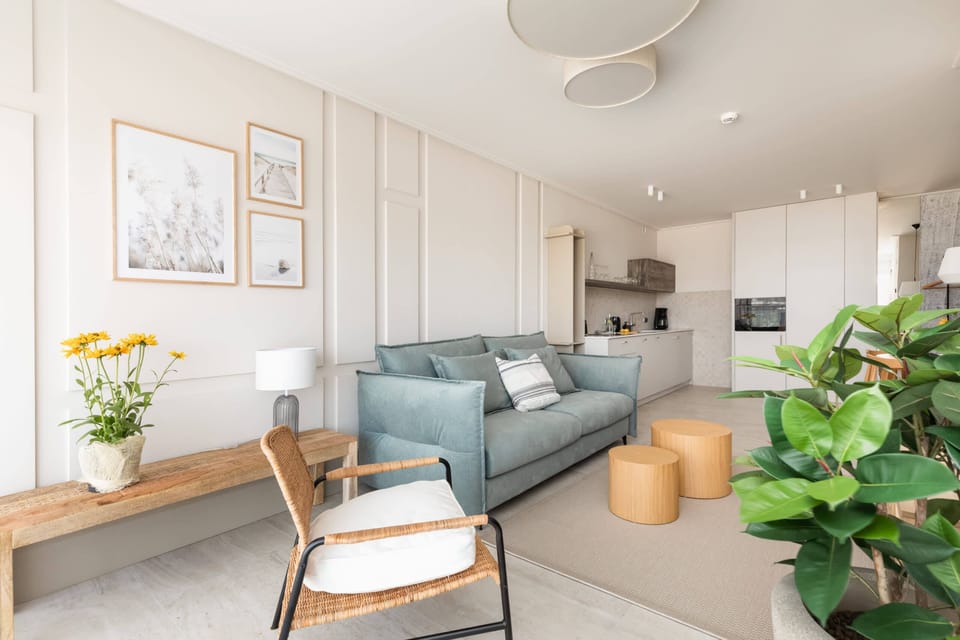 The open-plan living area includes stylish wooden accents, soft furnishings, and a light-filled ambiance.