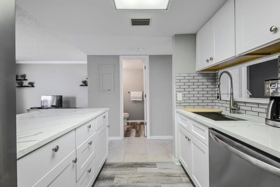 Modern kitchen with white cabinetry and stainless steel appliances