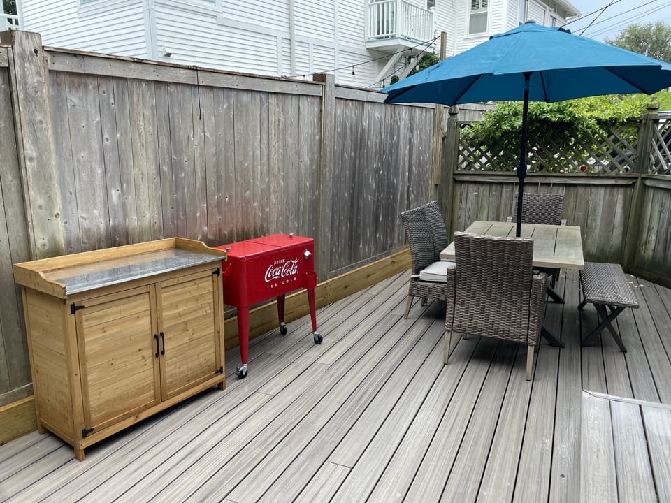 Comfortable outdoor dining area with umbrella. Cooler to keep your drinks cold.