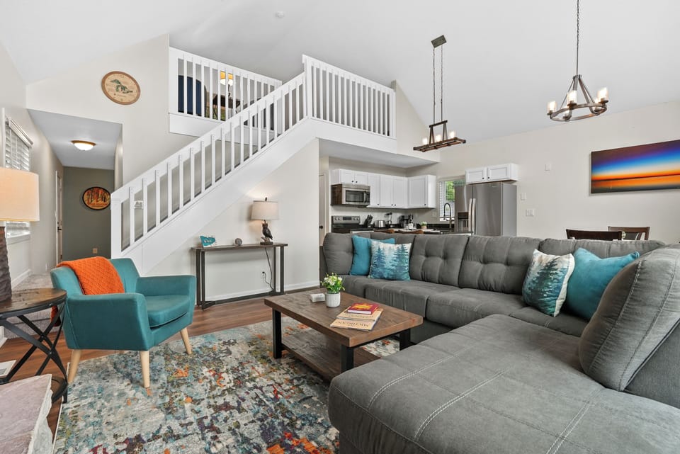 Open Living Room with stairs leading up to the Loft & mud room around the corner