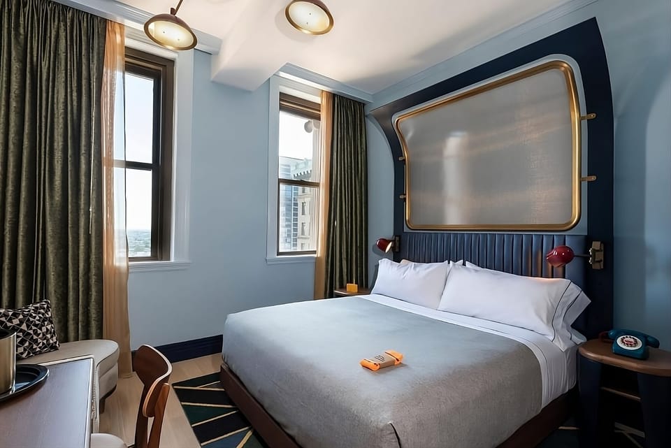 Unwind in crisp linens beneath bold, boutique-style headboard.
