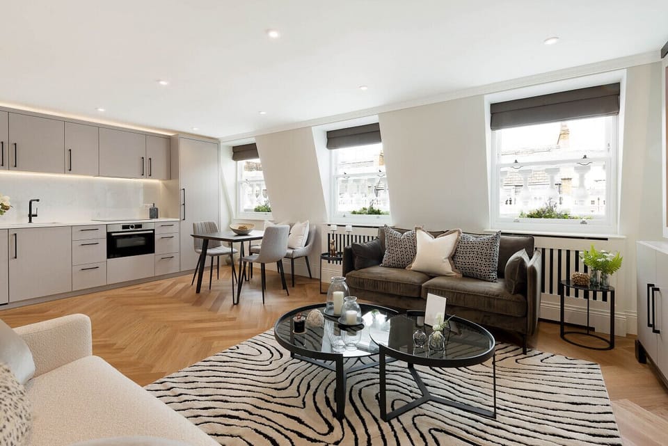 Living room — double sofa bed always made up and ready to use with extra pillows and blankets provided, alongside a coffee table and open-plan living space with hardwood flooring and bespoke cabinetry