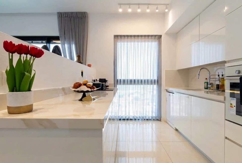 Bright kitchen island and workspace support easy cooking, with shops and supermarkets conveniently close by.