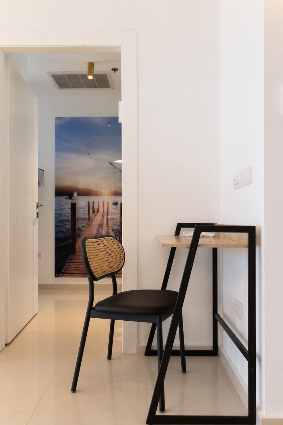 Entry nook with chair and console provides practical space for quick stops before heading outside.
