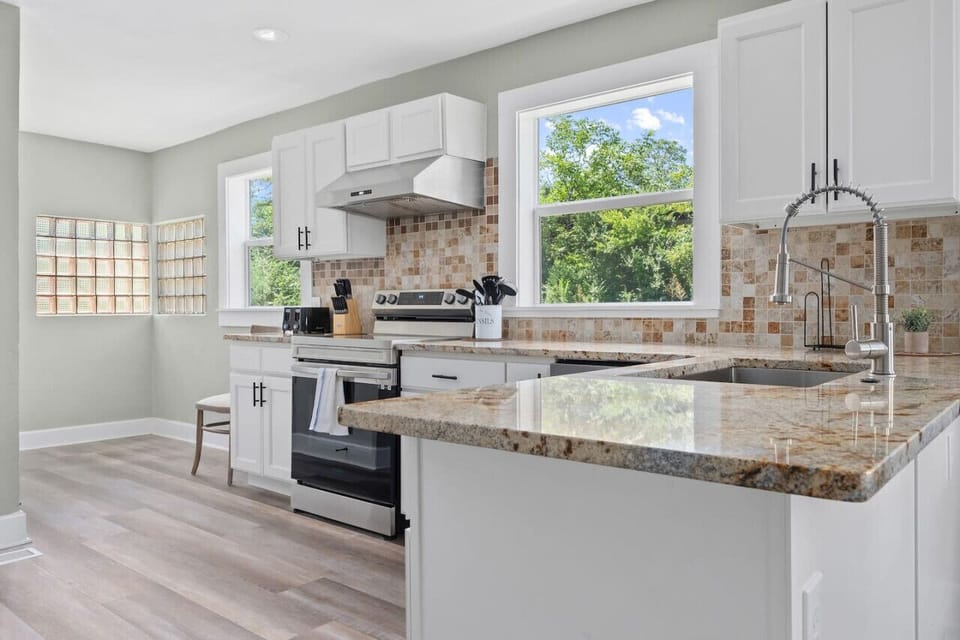 Modern kitchen with granite countertops, fully equipped for home-cooked meals during your stay.